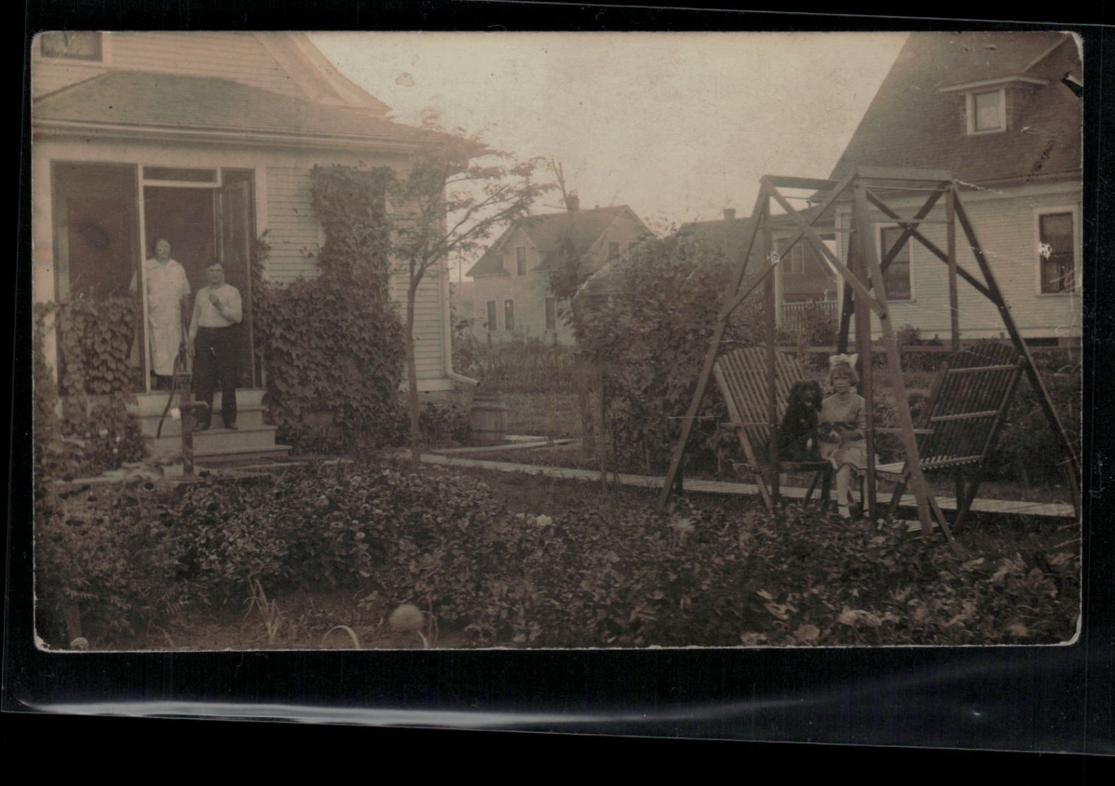 RPPC Postcard Backyard Scene, Girl with Dog on Chair, Water Pump c1914 – Trimmed