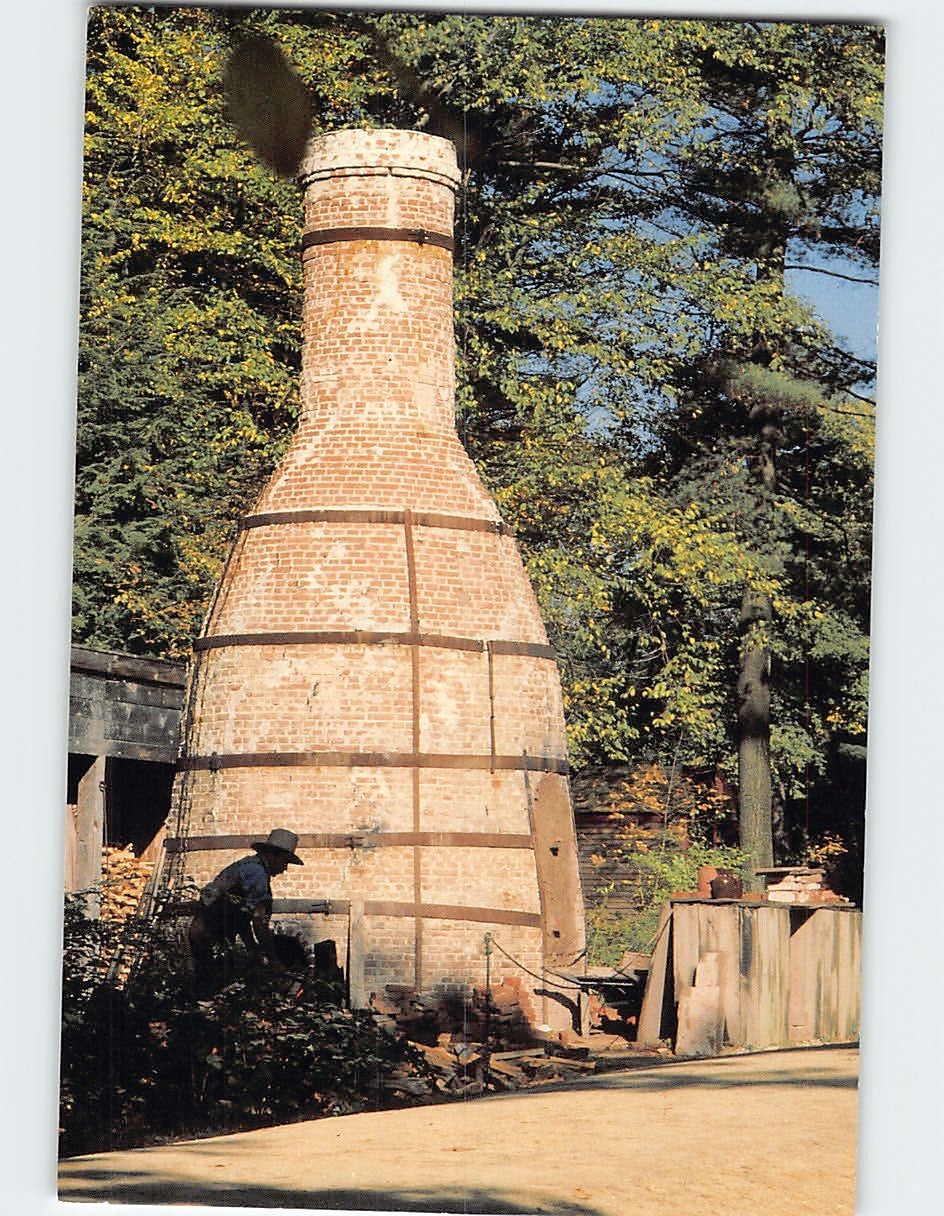 Postcard Potter chops wood for firing the kiln Old Sturbridge Village MA USA